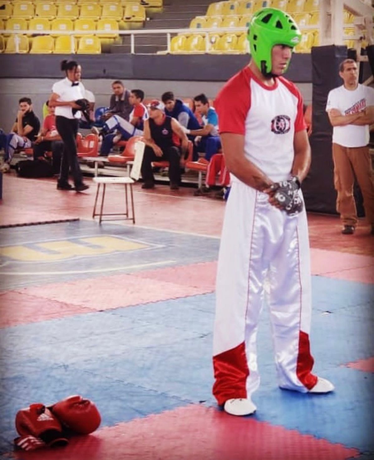 Jesus Barboza compitiendo en torneo de kickboxing con uniforme blanco y rojo